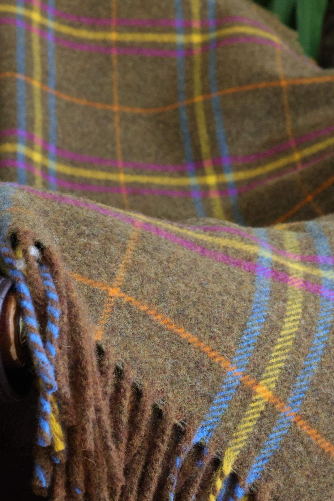 Nahaufnahme des Cairngorm Tartanmusters — Braun-Beige Grundton mit Pink, Gelb und Blau, Lammwolle gewebt für Kuuhi Scotland