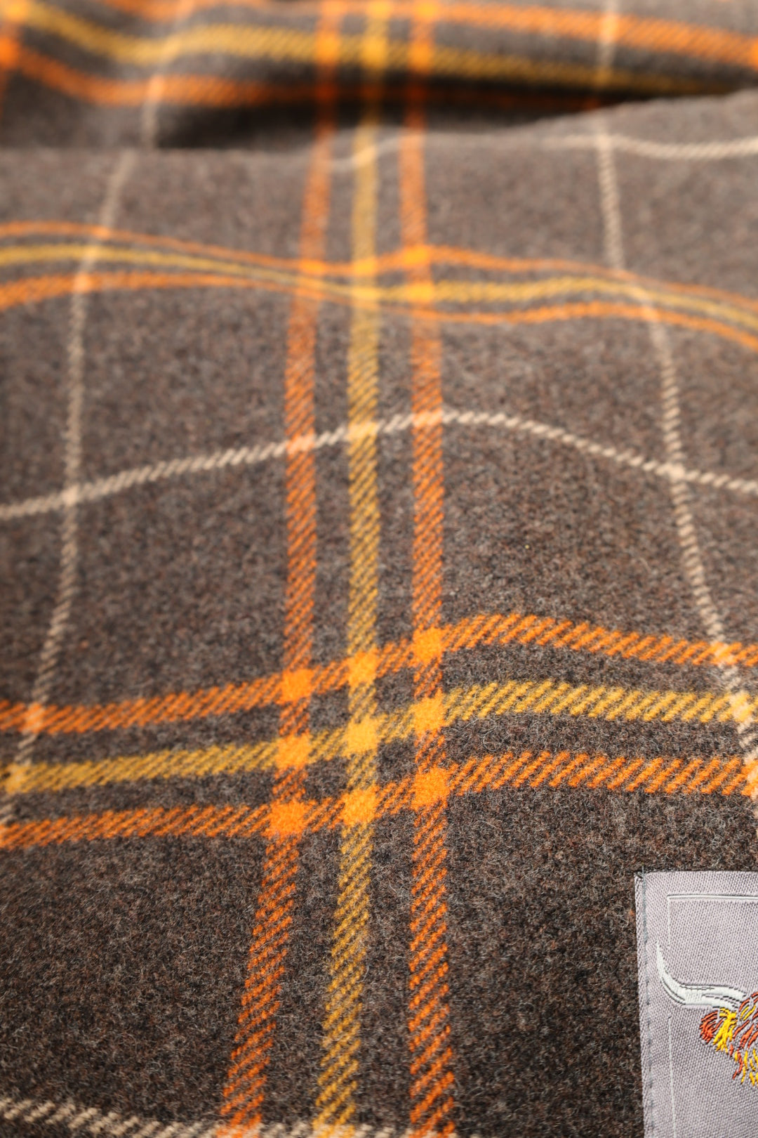 Schottische Wolldecke Dunoon in Grau, Orange und Gelb — Kuuhi Tartanmuster im Wohnzimmer