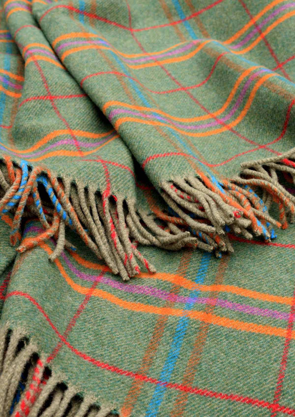 Nahaufnahme des Ailsa Craig Tartanmusters – Grün, Rost, Orange und Lila Lammwolle, gewebt für Kuuhi Scotland