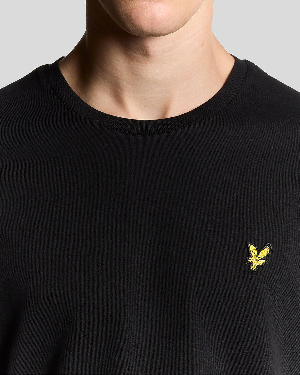 Lyle & Scott Herren T-Shirt Rundhals Jet Black — Detailansicht goldene Adler-Stickerei